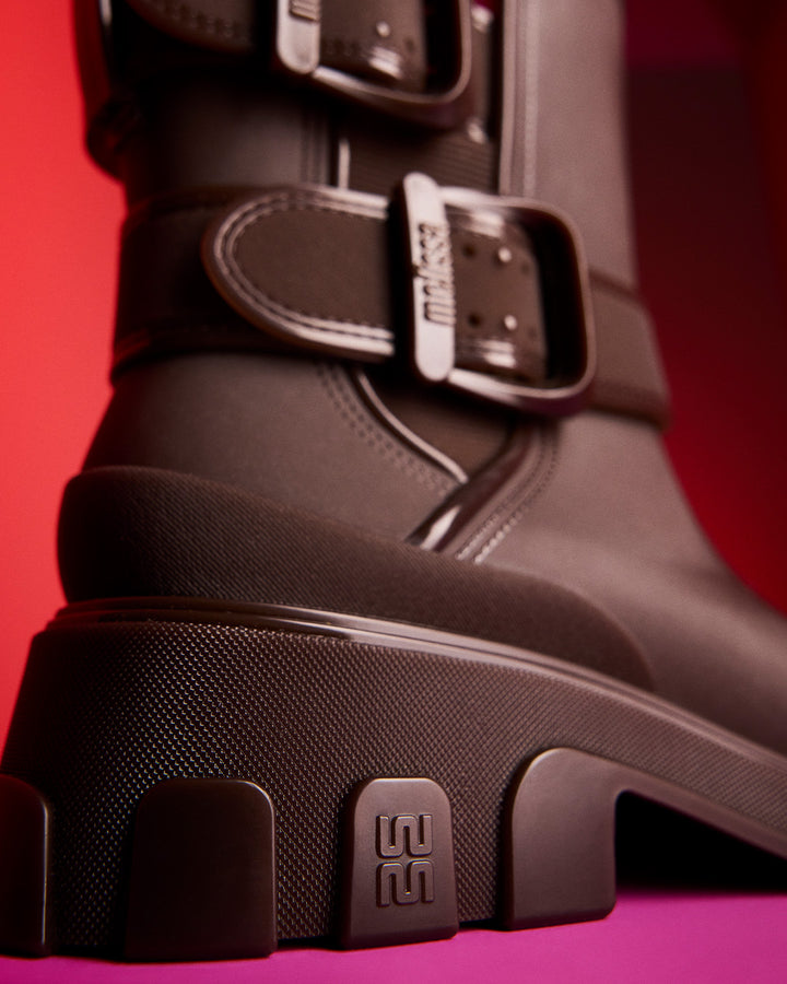 Bota adulta Melissa Bang Boot na cor marrom, com design robusto, salto tratorado, cano médio e duas fivelas laterais ajustáveis. Produzida em Melflex, une estilo urbano, conforto e resistência para looks modernos e ousados.

Palavra-chave principal: Melissa Bang Boot Bota Adulto
Palavras-chave relacionadas: bota marrom feminina, bota com fivelas, bota cano médio Melissa, bota tratorada, calçado urbano estiloso