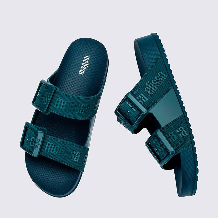 Chinelo adulto Melissa Cozy Slide M.Lover na cor azul médio, com duas tiras largas ajustáveis com fivelas e logo em relevo. Confeccionado em Melflex, com solado tratorado e palmilha anatômica. Perfeito para looks casuais com conforto e estilo despojado.

Palavra-chave principal: Melissa Cozy Slide M.Lover
Palavras-chave relacionadas: chinelo azul médio, slide adulto, Melflex, tiras com fivela, calçado casual, solado tratorado, conforto e estilo.