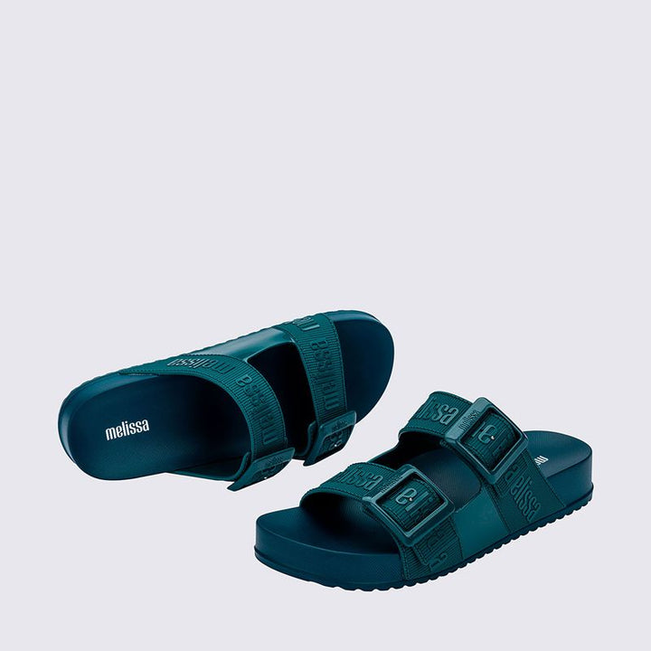 Chinelo adulto Melissa Cozy Slide M.Lover na cor azul médio, com duas tiras largas ajustáveis com fivelas e logo em relevo. Confeccionado em Melflex, com solado tratorado e palmilha anatômica. Perfeito para looks casuais com conforto e estilo despojado.

Palavra-chave principal: Melissa Cozy Slide M.Lover
Palavras-chave relacionadas: chinelo azul médio, slide adulto, Melflex, tiras com fivela, calçado casual, solado tratorado, conforto e estilo.