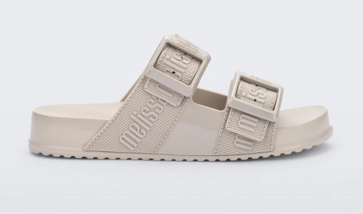 Chinelo adulto Melissa Cozy Slide M.Lover na cor bege claro, com duas tiras largas ajustáveis com fivelas e logo em relevo. Fabricado em Melflex, com solado tratorado e palmilha anatômica. Ideal para quem busca conforto, praticidade e estilo clean no dia a dia.

Palavra-chave principal: Melissa Cozy Slide M.Lover
Palavras-chave relacionadas: chinelo bege claro, slide adulto, tiras com fivela, Melflex, calçado confortável, solado tratorado, estilo minimalista.