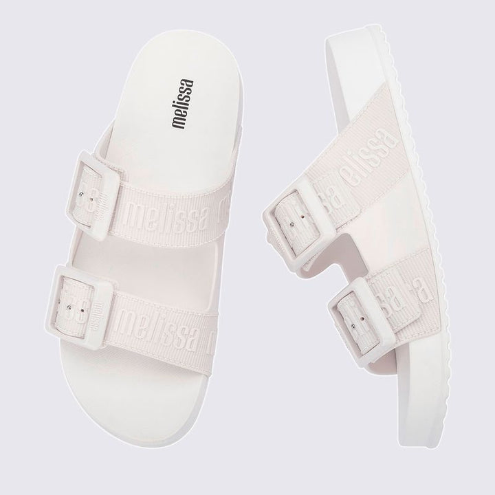 Chinelo adulto Melissa Cozy Slide M.Lover na cor branca, com duas tiras largas ajustáveis com fivelas e logo em relevo. Produzido em Melflex, com solado tratorado e palmilha anatômica. Ideal para looks casuais com conforto, leveza e estilo clean.

Palavra-chave principal: Melissa Cozy Slide M.Lover
Palavras-chave relacionadas: chinelo branco, slide feminino, Melflex, tiras com fivela, solado tratorado, calçado casual, estilo minimalista.