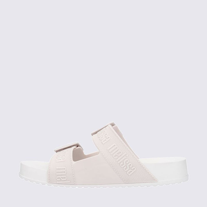 Chinelo adulto Melissa Cozy Slide M.Lover na cor branca, com duas tiras largas ajustáveis com fivelas e logo em relevo. Produzido em Melflex, com solado tratorado e palmilha anatômica. Ideal para looks casuais com conforto, leveza e estilo clean.

Palavra-chave principal: Melissa Cozy Slide M.Lover
Palavras-chave relacionadas: chinelo branco, slide feminino, Melflex, tiras com fivela, solado tratorado, calçado casual, estilo minimalista.