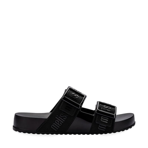 Chinelo adulto Melissa Cozy Slide M.Lover na cor preta, com duas tiras largas ajustáveis com fivelas e logo em relevo. Produzido em Melflex, conta com solado tratorado e palmilha anatômica. Perfeito para compor looks casuais com conforto, praticidade e estilo urbano.

Palavra-chave principal: Melissa Cozy Slide M.Lover
Palavras-chave relacionadas: chinelo preto, slide adulto, tiras com fivela, Melflex, palmilha anatômica, calçado casual, solado tratorado.
