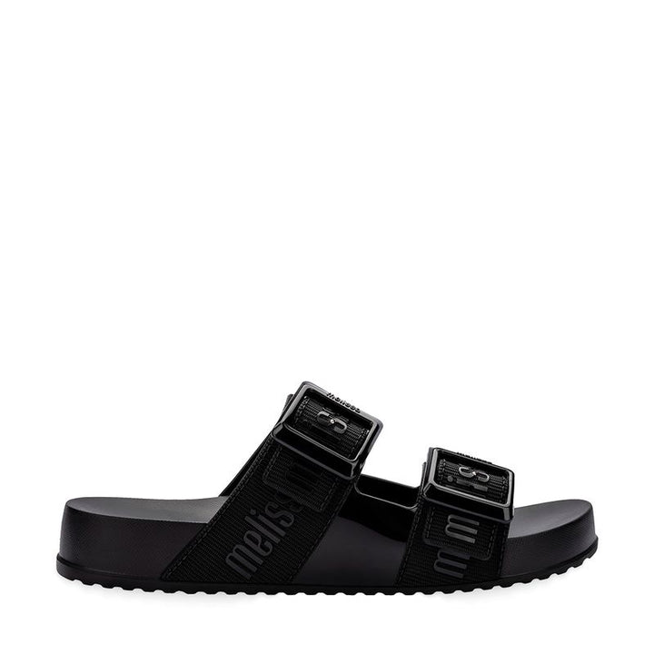 Chinelo adulto Melissa Cozy Slide M.Lover na cor preta, com duas tiras largas ajustáveis com fivelas e logo em relevo. Produzido em Melflex, conta com solado tratorado e palmilha anatômica. Perfeito para compor looks casuais com conforto, praticidade e estilo urbano.

Palavra-chave principal: Melissa Cozy Slide M.Lover
Palavras-chave relacionadas: chinelo preto, slide adulto, tiras com fivela, Melflex, palmilha anatômica, calçado casual, solado tratorado.