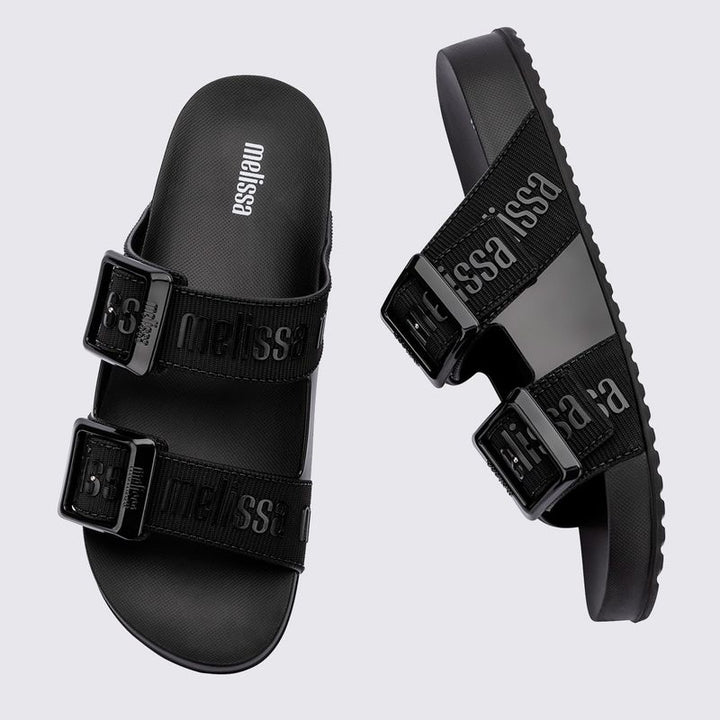 Chinelo adulto Melissa Cozy Slide M.Lover na cor preta, com duas tiras largas ajustáveis com fivelas e logo em relevo. Produzido em Melflex, conta com solado tratorado e palmilha anatômica. Perfeito para compor looks casuais com conforto, praticidade e estilo urbano.

Palavra-chave principal: Melissa Cozy Slide M.Lover
Palavras-chave relacionadas: chinelo preto, slide adulto, tiras com fivela, Melflex, palmilha anatômica, calçado casual, solado tratorado.
