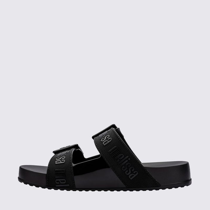 Chinelo adulto Melissa Cozy Slide M.Lover na cor preta, com duas tiras largas ajustáveis com fivelas e logo em relevo. Produzido em Melflex, conta com solado tratorado e palmilha anatômica. Perfeito para compor looks casuais com conforto, praticidade e estilo urbano.

Palavra-chave principal: Melissa Cozy Slide M.Lover
Palavras-chave relacionadas: chinelo preto, slide adulto, tiras com fivela, Melflex, palmilha anatômica, calçado casual, solado tratorado.