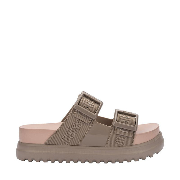 Sandália plataforma Melissa Cozy M.Lover na cor bege médio, com duas tiras largas ajustáveis com fivelas e logo Melissa em relevo. Produzida em Melflex, possui solado alto tratorado e palmilha anatômica, unindo conforto, estilo e praticidade em um visual moderno