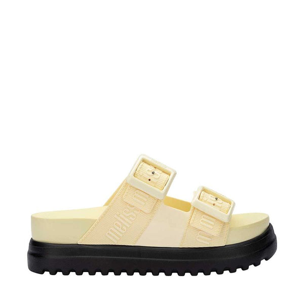 Sandália plataforma Melissa Cozy M.Lover nas cores bege e preto, com duas tiras largas ajustáveis com fivelas e logo Melissa em relevo. Produzida em Melflex, possui solado tratorado alto e palmilha anatômica. Ideal para compor looks casuais com conforto e estilo moderno