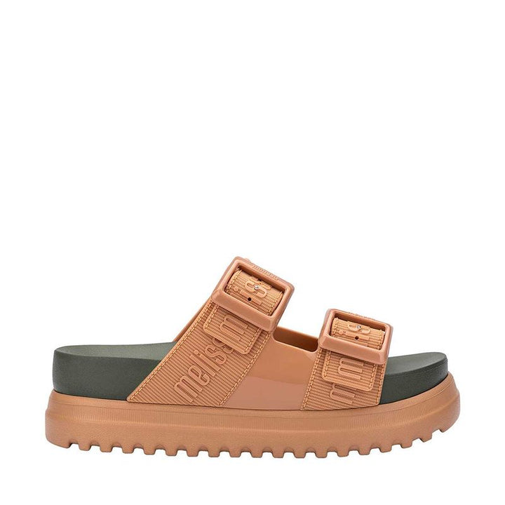 Sandália plataforma adulta Melissa Cozy M.Lover nas cores bege e verde, com duas tiras largas ajustáveis com fivelas e logo em relevo. Confeccionada em Melflex, possui solado tratorado e palmilha anatômica. Ideal para quem busca estilo, conforto e um visual moderno e ousado