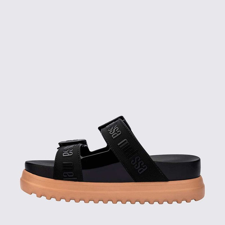 Sandália plataforma Melissa Cozy M.Lover na cor preta, com duas tiras largas ajustáveis com fivelas e logo em relevo. Produzida em Melflex, conta com solado tratorado e palmilha anatômica. Ideal para compor looks casuais com conforto, atitude e estilo urbano