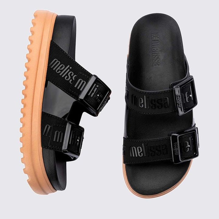 Sandália plataforma Melissa Cozy M.Lover na cor preta, com duas tiras largas ajustáveis com fivelas e logo em relevo. Produzida em Melflex, conta com solado tratorado e palmilha anatômica. Ideal para compor looks casuais com conforto, atitude e estilo urbano