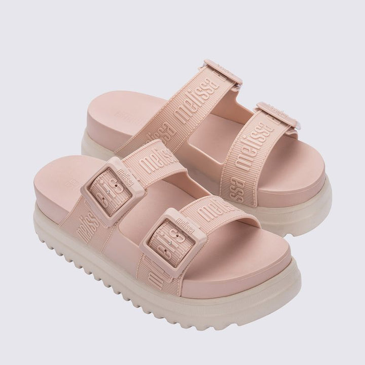 Sandália plataforma Melissa Cozy M.Lover nas cores rosa e bege, com duas tiras largas ajustáveis com fivelas e logo em relevo. Confeccionada em Melflex, possui solado alto tratorado e palmilha anatômica. Ideal para looks casuais com conforto, estilo e atitude