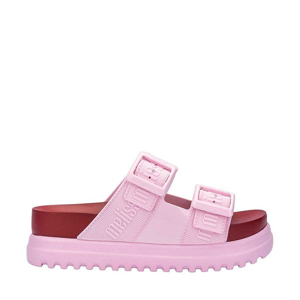 Sandália plataforma adulta Melissa Cozy M.Lover nas cores rosa e vermelho, com duas tiras largas ajustáveis com fivelas e logo em relevo. Produzida em Melflex, com solado tratorado alto e palmilha anatômica, combina conforto, estilo marcante e atitude nos looks casuais