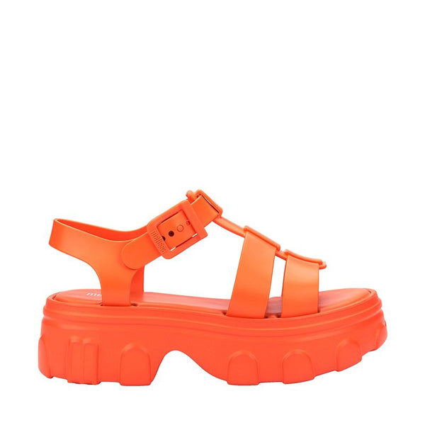Sandália adulta Melissa Ella na cor laranja, com tiras largas, acabamento brilhante e fecho ajustável no tornozelo. Produzida em Melflex, é leve, confortável e perfeita para compor looks casuais vibrantes com estilo e praticidade.