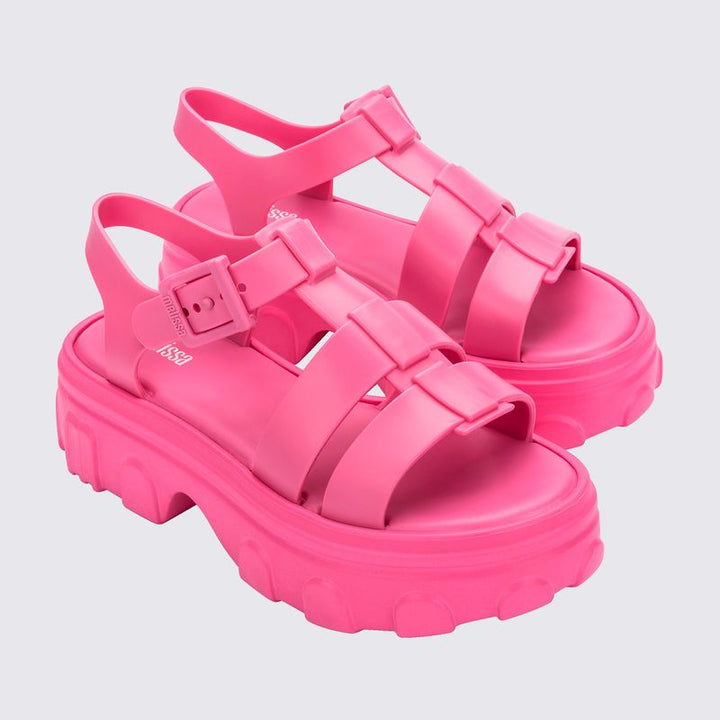 Sandália adulta Melissa Ella na cor rosa, com tiras largas, fecho ajustável no tornozelo e acabamento brilhante. Produzida em Melflex, é leve, confortável e ideal para compor looks casuais e românticos com um toque de estilo moderno