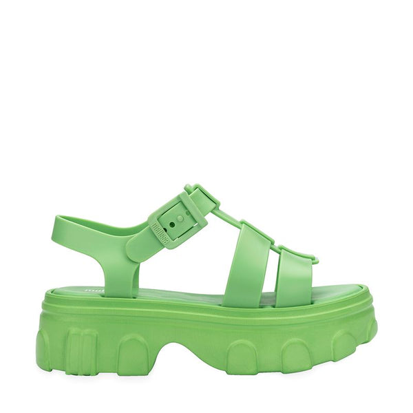 Sandália adulta Melissa Ella na cor verde, com tiras largas e design moderno. Produzida em Melflex, possui solado baixo, acabamento brilhante e fecho ajustável no tornozelo. Ideal para compor looks casuais com conforto e estilo