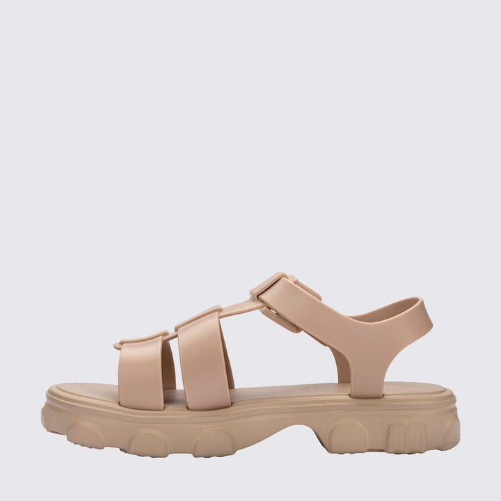 Sandália Melissa Ella na cor bege, com tiras finas, design minimalista e fecho ajustável no tornozelo. Confeccionada em Melflex, é leve, confortável e elegante, perfeita para compor looks casuais, delicados e versáteis no dia a dia