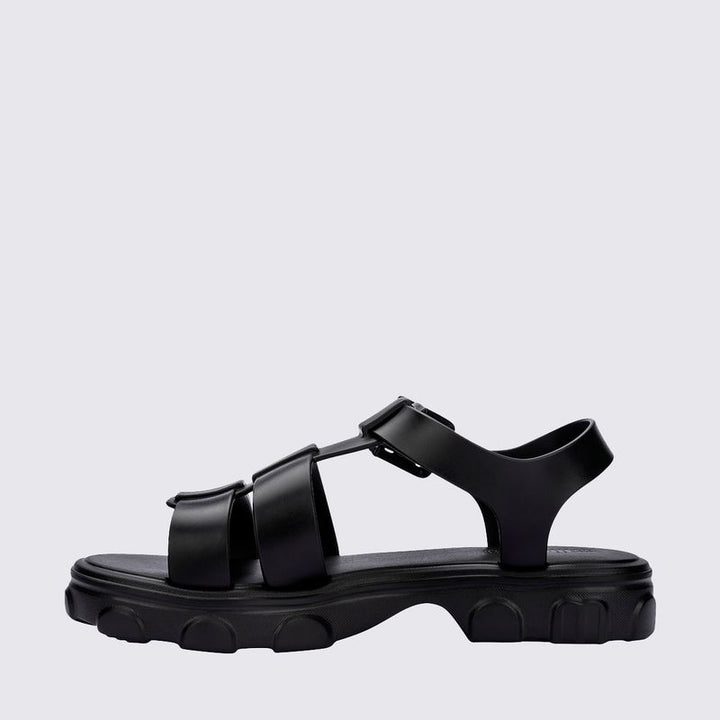 Sandália Melissa Ella na cor preta, com design minimalista, tiras finas e fecho ajustável no tornozelo. Produzida em Melflex, é leve, confortável e elegante, ideal para compor looks casuais e sofisticados com praticidade no dia a dia