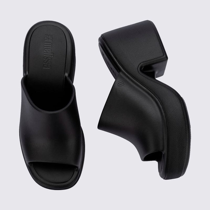 Tamanco adulto Melissa Free High na cor preta, com salto plataforma robusto, bico arredondado e cabedal fechado com abertura frontal. Produzido em Melflex, combina conforto, estilo e praticidade para compor looks modernos e ousados.

Palavra-chave principal: Melissa Free High Tamanco Adulto
Palavras-chave relacionadas: tamanco preto Melissa, salto plataforma, calçado confortável, Melflex, tamanco moderno, tamanco feminino estiloso.