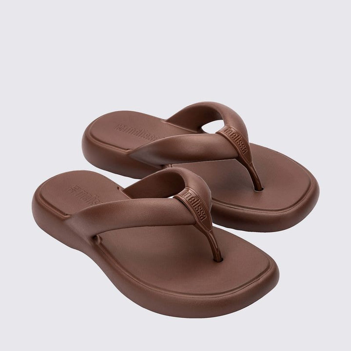 Chinelo adulto Melissa Free Low na cor bronze, com design minimalista, tiras grossas estilo flip-flop e solado anatômico. Confeccionado em Melflex, oferece leveza, conforto e praticidade para o dia a dia com muito estilo.

Palavra-chave principal: Melissa Free Low Chinelo Adulto
Palavras-chave relacionadas: chinelo bronze Melissa, flip-flop feminino, Melflex, chinelo confortável, solado anatômico, calçado casual.