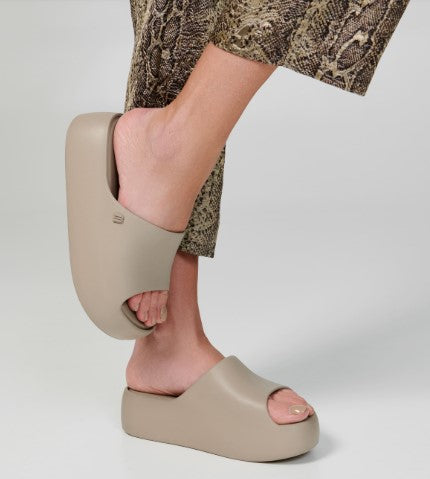 Sandália Melissa Free Platform Slide adulto na cor bege escuro, com tira única larga, solado plataforma e design minimalista – calçado moderno, leve e confortável.

Palavra-chave principal:
Melissa Free Platform Slide

Palavras-chave relacionadas:
Melissa 35859, sandália slide bege escuro, plataforma Melissa, slide feminino, calçado confortável Melissa, sandália minimalista, Melissa com solado alto, sandália moderna, slide casual Melissa, sandália leve adulto