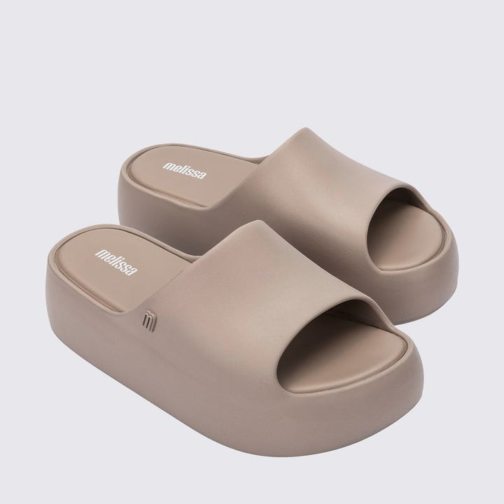 Sandália Melissa Free Platform Slide adulto na cor bege escuro, com tira única larga, solado plataforma e design minimalista – calçado moderno, leve e confortável.

Palavra-chave principal:
Melissa Free Platform Slide

Palavras-chave relacionadas:
Melissa 35859, sandália slide bege escuro, plataforma Melissa, slide feminino, calçado confortável Melissa, sandália minimalista, Melissa com solado alto, sandália moderna, slide casual Melissa, sandália leve adulto