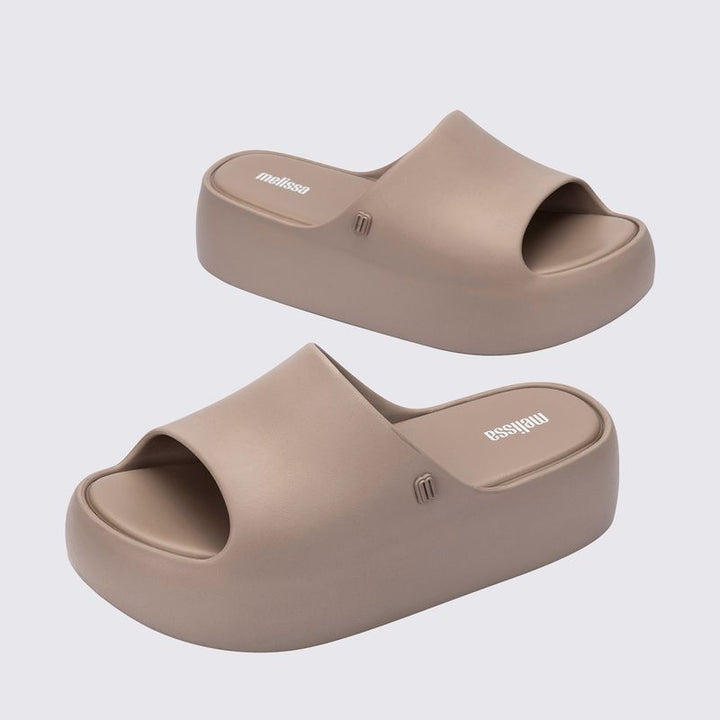 Sandália Melissa Free Platform Slide adulto na cor bege escuro, com tira única larga, solado plataforma e design minimalista – calçado moderno, leve e confortável.

Palavra-chave principal:
Melissa Free Platform Slide

Palavras-chave relacionadas:
Melissa 35859, sandália slide bege escuro, plataforma Melissa, slide feminino, calçado confortável Melissa, sandália minimalista, Melissa com solado alto, sandália moderna, slide casual Melissa, sandália leve adulto
