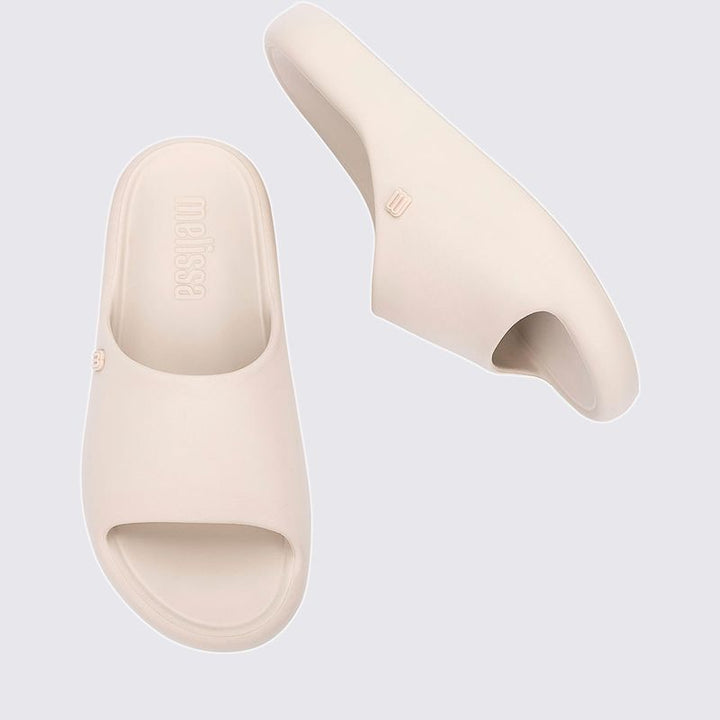 Chinelo adulto Melissa Free Print Slide na cor bege, com uma tira larga, design minimalista e solado reto. Produzido em Melflex, leve e confortável, ideal para compor looks casuais com estilo e praticidade."

Palavra-chave principal: Chinelo adulto Melissa Free Print Slide
Palavras-chave relacionadas: bege, uma tira, Melflex, chinelo feminino, slide confortável, calçado casual, estilo minimalista.