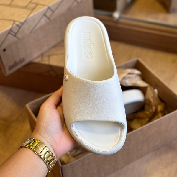 Chinelo adulto Melissa Free Print Slide na cor bege, com uma tira larga, design minimalista e solado reto. Produzido em Melflex, leve e confortável, ideal para compor looks casuais com estilo e praticidade."

Palavra-chave principal: Chinelo adulto Melissa Free Print Slide
Palavras-chave relacionadas: bege, uma tira, Melflex, chinelo feminino, slide confortável, calçado casual, estilo minimalista.