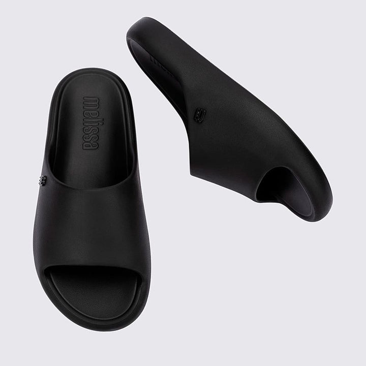 Chinelo adulto Melissa Free Print Slide na cor preta, com design minimalista, tira larga e solado reto. Produzido em Melflex, oferece conforto e praticidade para o dia a dia, perfeito para compor looks casuais com estilo."

Palavra-chave principal: Chinelo adulto Melissa Free Print Slide
Palavras-chave relacionadas: preto, Melflex, chinelo confortável, slide feminino, calçado casual, design minimalista.