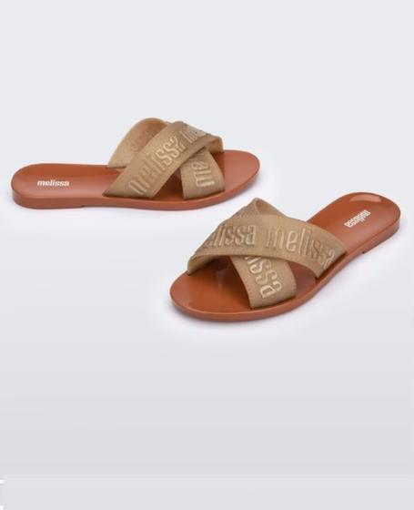 Sandália Melissa M Lover Slide adulto nas cores marrom e ouro, com tira larga texturizada, solado reto e design minimalista – calçado moderno, confortável e ideal para o dia a dia.

Palavra-chave principal:
Melissa M Lover Slide

Palavras-chave relacionadas:
Melissa 35740, slide marrom ouro Melissa, sandália bicolor Melissa, calçado confortável adulto, Melissa com tira larga, sandália minimalista, slide casual, sandália estilosa feminina, Melissa moderna, sandália leve adulto