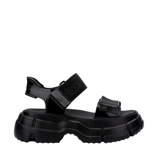 Sandália Melissa Pulse na cor preta, com tiras largas e fechamento ajustável no tornozelo. Produzida em Melflex, possui solado robusto que garante conforto e estilo. Ideal para compor looks urbanos, modernos e versáteis no dia a dia