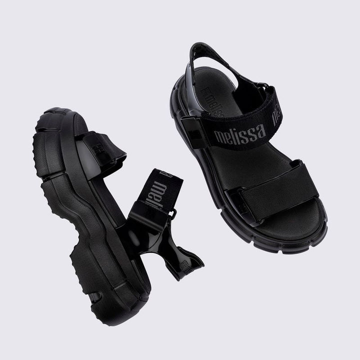 Sandália Melissa Pulse na cor preta, com tiras largas e fechamento ajustável no tornozelo. Produzida em Melflex, possui solado robusto que garante conforto e estilo. Ideal para compor looks urbanos, modernos e versáteis no dia a dia