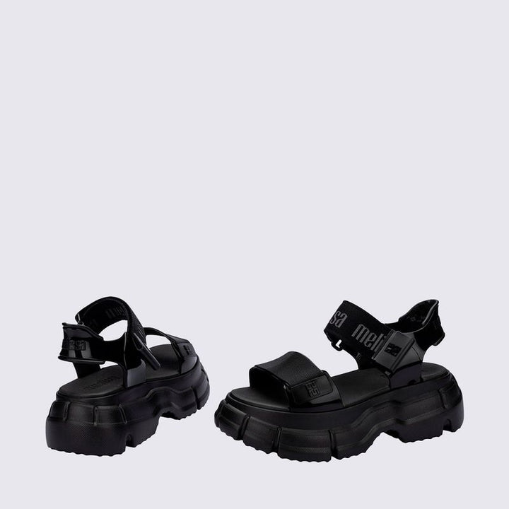 Sandália Melissa Pulse na cor preta, com tiras largas e fechamento ajustável no tornozelo. Produzida em Melflex, possui solado robusto que garante conforto e estilo. Ideal para compor looks urbanos, modernos e versáteis no dia a dia