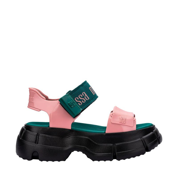 Sandália Melissa Pulse nas cores preto e rosa, com tiras largas e fechamento ajustável no tornozelo. Confeccionada em Melflex, possui solado robusto e confortável. Perfeita para looks urbanos e estilosos, unindo praticidade, personalidade e design moderno
