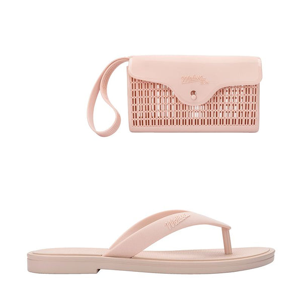 chinelo, com acabamento fosco e feito em Melflex, é superconfortável, resistente e ideal para o dia a dia — desde um passeio no parque até aquele almoço de domingo em família. Já a bolsa bege que acompanha é um show à parte: compacta, mas espaçosa, com 1 litro de capacidade, perfeita para carregar os itens essenciais com estilo.