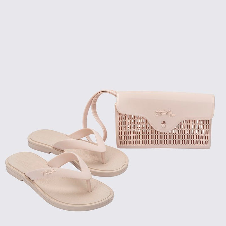 chinelo, com acabamento fosco e feito em Melflex, é superconfortável, resistente e ideal para o dia a dia — desde um passeio no parque até aquele almoço de domingo em família. Já a bolsa bege que acompanha é um show à parte: compacta, mas espaçosa, com 1 litro de capacidade, perfeita para carregar os itens essenciais com estilo.