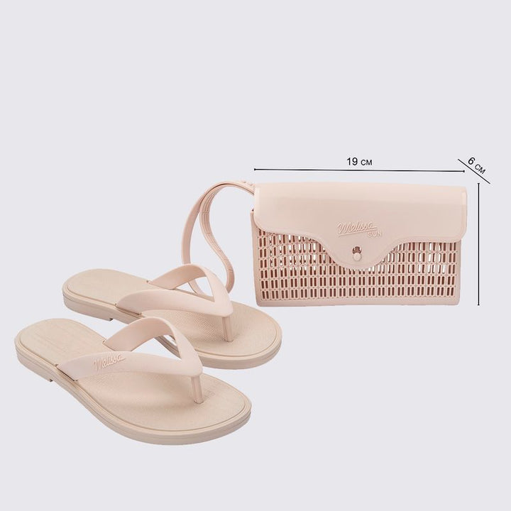 chinelo, com acabamento fosco e feito em Melflex, é superconfortável, resistente e ideal para o dia a dia — desde um passeio no parque até aquele almoço de domingo em família. Já a bolsa bege que acompanha é um show à parte: compacta, mas espaçosa, com 1 litro de capacidade, perfeita para carregar os itens essenciais com estilo.