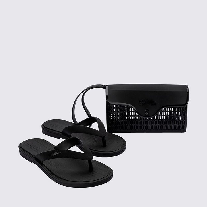 chinelo preto, feito com Melflex e acabamento fosco, é perfeito para usar o dia todo, com máximo conforto e estilo. Já a bolsa de mão, também em preto, tem capacidade de 1 litro e o tamanho ideal pra carregar os seus essenciais com organização e muito charme.