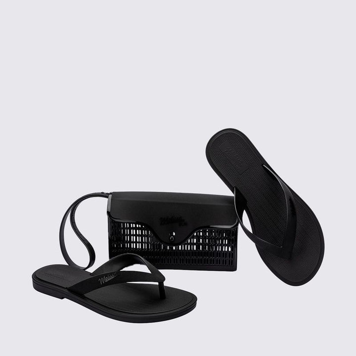 chinelo preto, feito com Melflex e acabamento fosco, é perfeito para usar o dia todo, com máximo conforto e estilo. Já a bolsa de mão, também em preto, tem capacidade de 1 litro e o tamanho ideal pra carregar os seus essenciais com organização e muito charme.