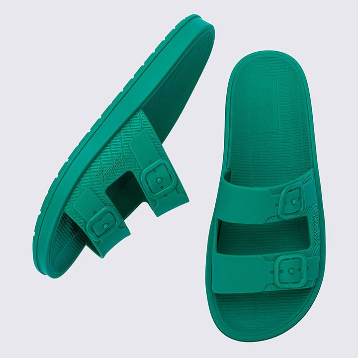 Sandália Melissa Sun Cruise adulto na cor verde com acabamento brilhante e translúcido. Feita em material Melflex, possui design moderno com tiras largas e confortáveis. O solado rasteiro oferece leveza e praticidade, e o fechamento ajustável garante segurança e conforto ao caminhar. Ideal para compor looks casuais, descontraídos e cheios de estilo.