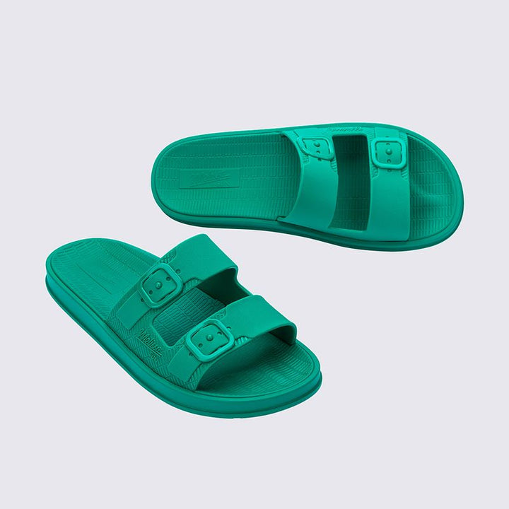 Sandália Melissa Sun Cruise adulto na cor verde com acabamento brilhante e translúcido. Feita em material Melflex, possui design moderno com tiras largas e confortáveis. O solado rasteiro oferece leveza e praticidade, e o fechamento ajustável garante segurança e conforto ao caminhar. Ideal para compor looks casuais, descontraídos e cheios de estilo.