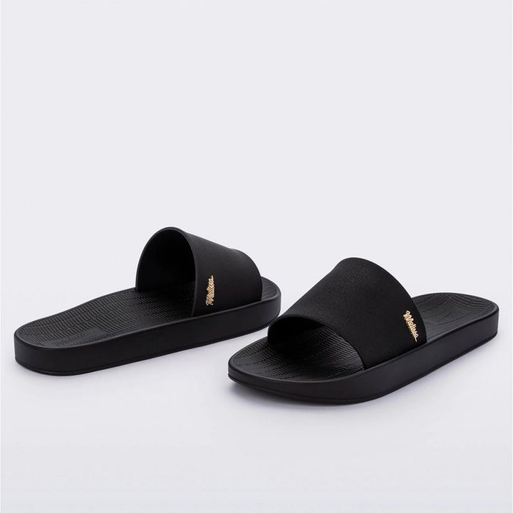 Chinelo slide Melissa Sun Sunset adulto na cor preta, com tira única larga, design minimalista e solado reto – calçado leve e confortável para o dia a dia.

Palavra-chave principal:
Melissa Sun Sunset Adulto

Palavras-chave relacionadas:
Chinelo slide Melissa
Melissa preta 33529
Chinelo feminino confortável
Slide Melissa preto
Melissa verão
Chinelo casual
Tira larga Melissa
Calçado leve adulto
Chinelo preto Melissa
Melissa solado reto
