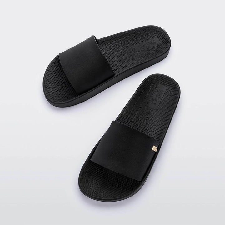 Chinelo slide Melissa Sun Sunset adulto na cor preta, com tira única larga, design minimalista e solado reto – calçado leve e confortável para o dia a dia.

Palavra-chave principal:
Melissa Sun Sunset Adulto

Palavras-chave relacionadas:
Chinelo slide Melissa
Melissa preta 33529
Chinelo feminino confortável
Slide Melissa preto
Melissa verão
Chinelo casual
Tira larga Melissa
Calçado leve adulto
Chinelo preto Melissa
Melissa solado reto