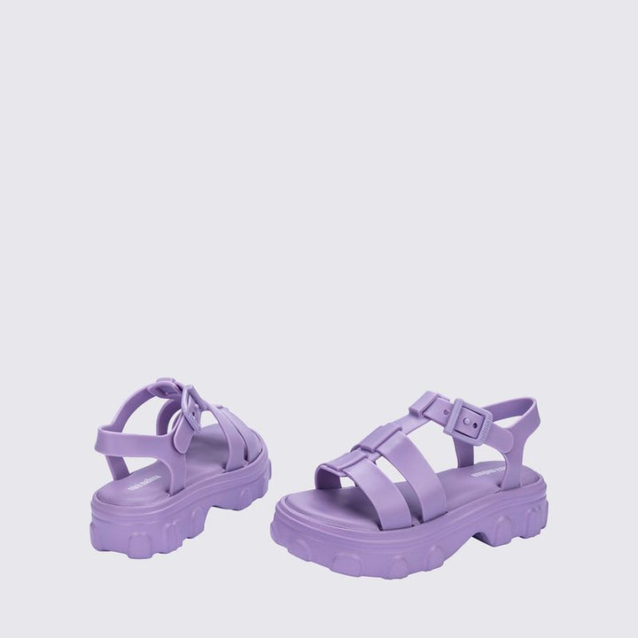 Sandália infantil Mini Melissa Ella na cor lilás, com tiras largas, acabamento brilhante e fecho ajustável no tornozelo. Produzida em Melflex, é leve, confortável e perfeita para compor looks delicados e estilosos no dia a dia das crianças