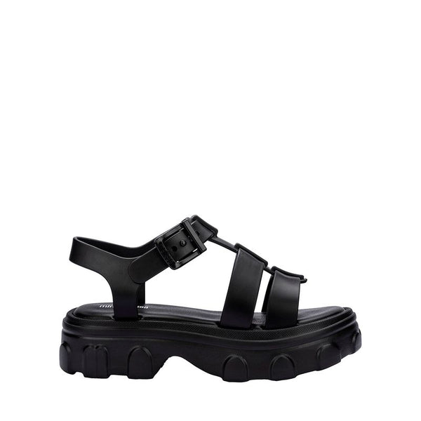 Sandália infantil Mini Melissa Ella na cor preta, com tiras largas, acabamento brilhante e fecho ajustável no tornozelo. Produzida em Melflex, é leve, confortável e ideal para compor looks infantis estilosos e práticos para o dia a dia