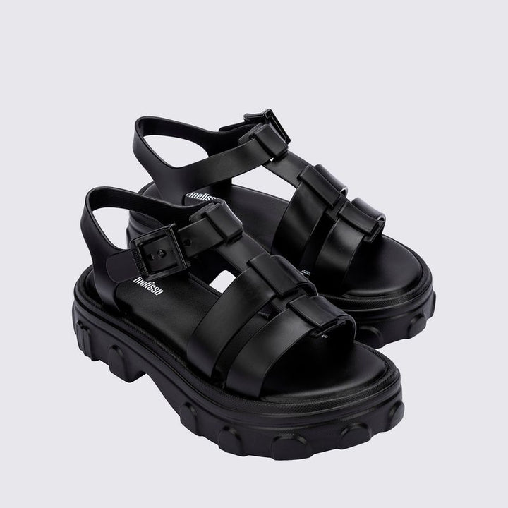 Sandália infantil Mini Melissa Ella na cor preta, com tiras largas, acabamento brilhante e fecho ajustável no tornozelo. Produzida em Melflex, é leve, confortável e ideal para compor looks infantis estilosos e práticos para o dia a dia