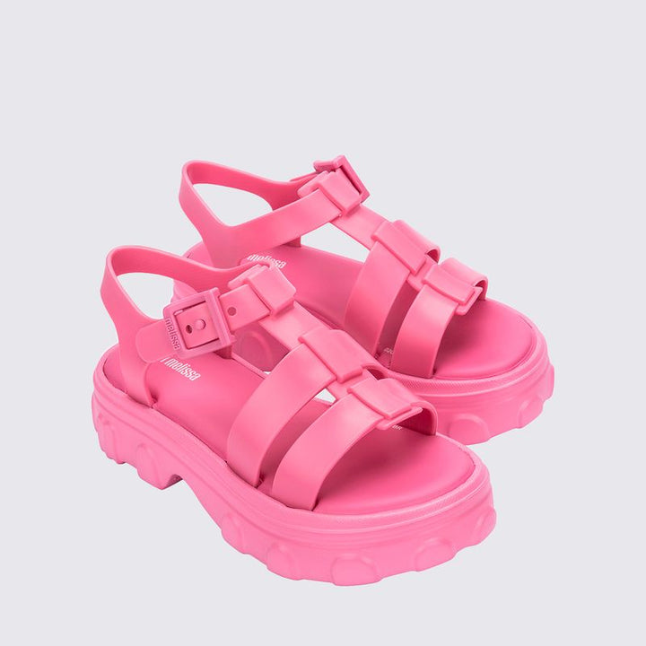 Sandália infantil Mini Melissa Ella na cor rosa, com tiras largas, acabamento brilhante e fecho ajustável no tornozelo. Feita em Melflex, é leve, confortável e ideal para compor looks infantis com estilo, praticidade e um toque delicado