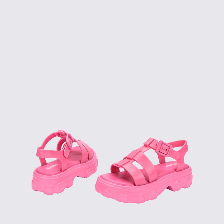 Sandália infantil Mini Melissa Ella na cor rosa, com tiras largas, acabamento brilhante e fecho ajustável no tornozelo. Feita em Melflex, é leve, confortável e ideal para compor looks infantis com estilo, praticidade e um toque delicado