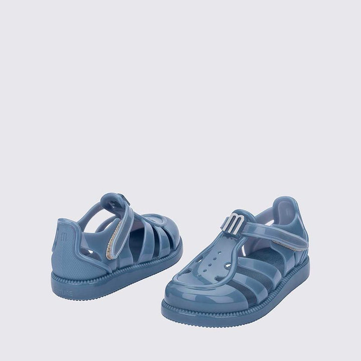Sandália infantil Mini Melissa Hip Daydream Baby na cor azul, com tiras vazadas, fechamento em velcro e detalhe com o 'M' da marca. Produzida em Melflex, é leve, confortável e segura, ideal para os primeiros passos com estilo e praticidade.

Palavra-chave principal: Mini Melissa Hip Daydream Baby
Palavras-chave relacionadas: sandália azul baby, Melflex, sandália infantil, fechamento em velcro, primeiros passos, calçado confortável, estilo baby.